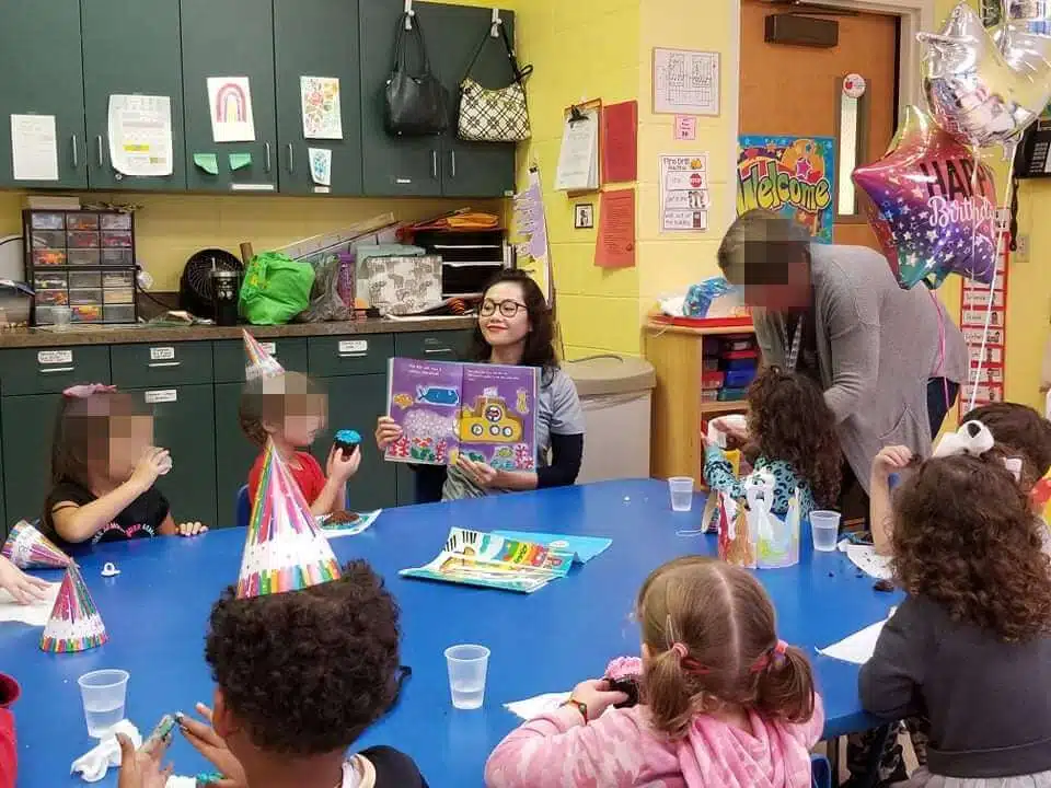 Dentist from Southern Style Dental reads to kids at a classroom birthday party, promoting oral hygiene and dental care.