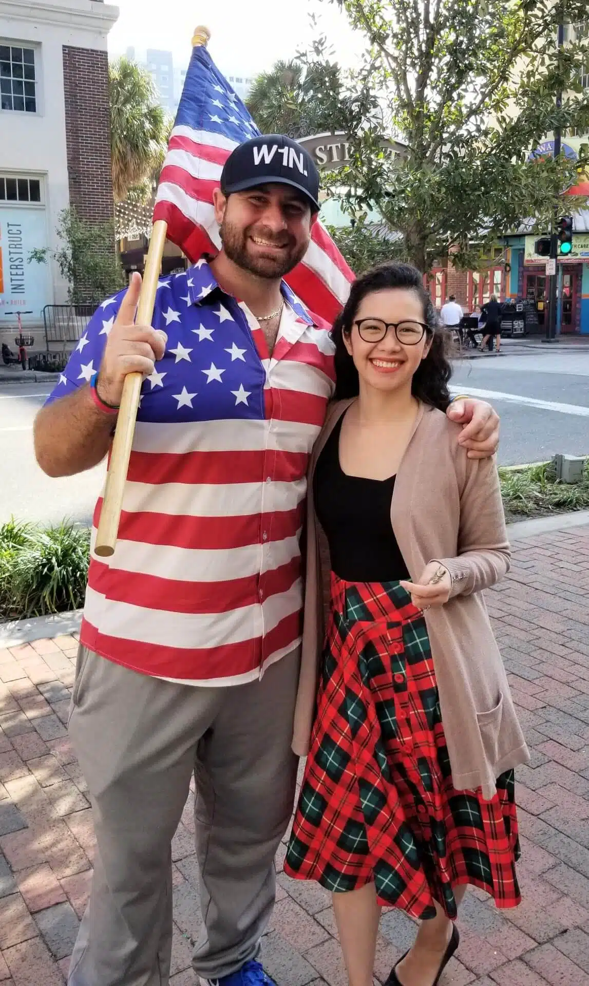 Two smiling people in festive attire with an American flag at Southern Style Dental community event.