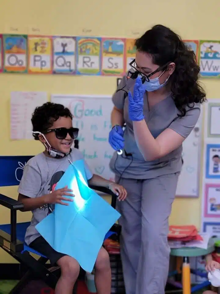 Pediatric dental check-up at Southern Style Dental – dentist and young patient smiling and wearing sunglasses.
