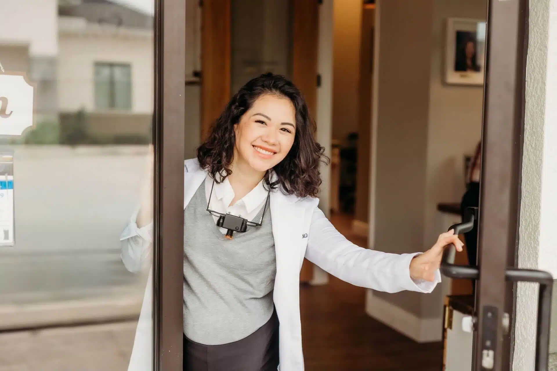 Smiling dentist welcoming patients at Southern Style Dental office entrance.