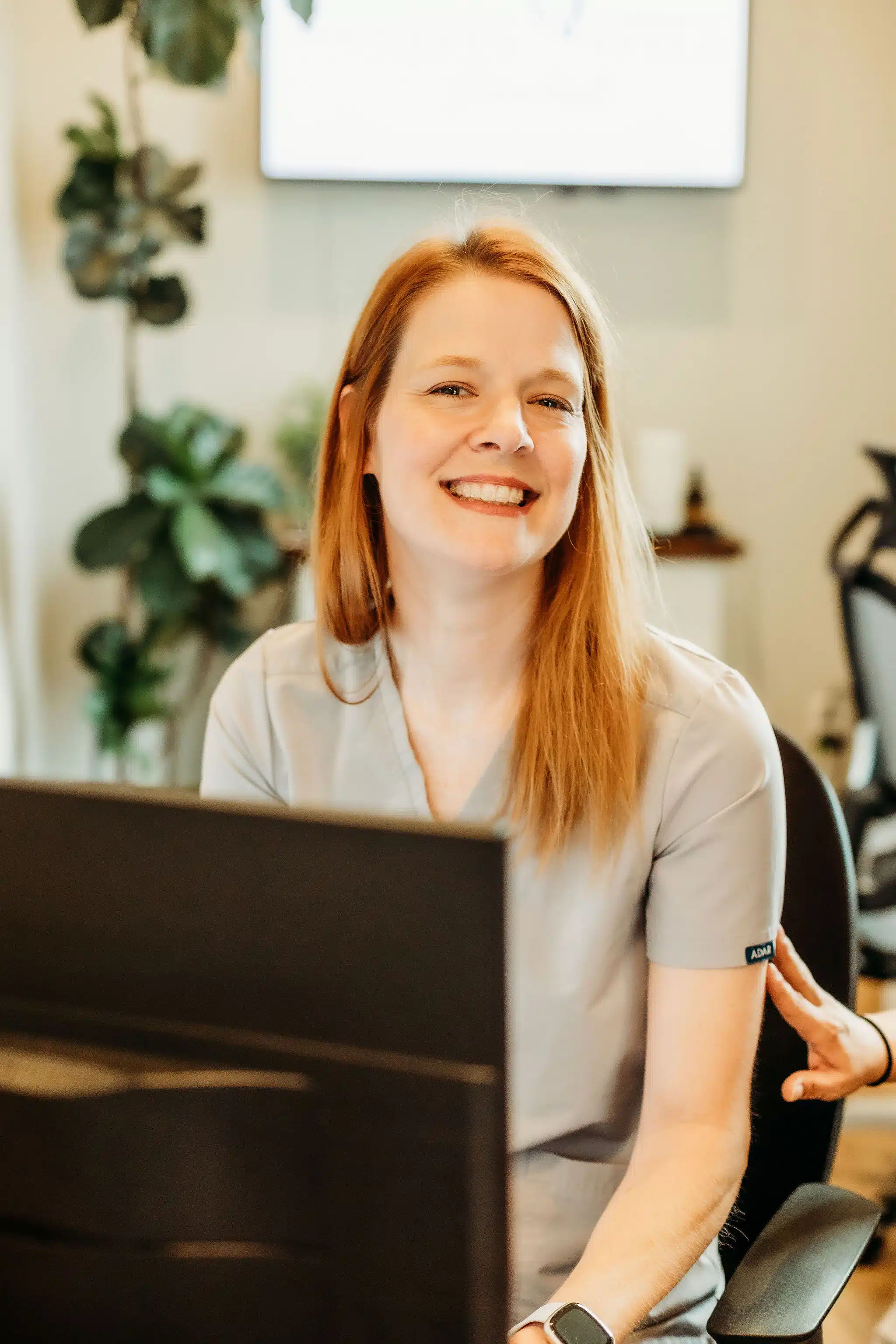 Smiling dental receptionist at Southern Style Dental welcoming patients at the front desk.