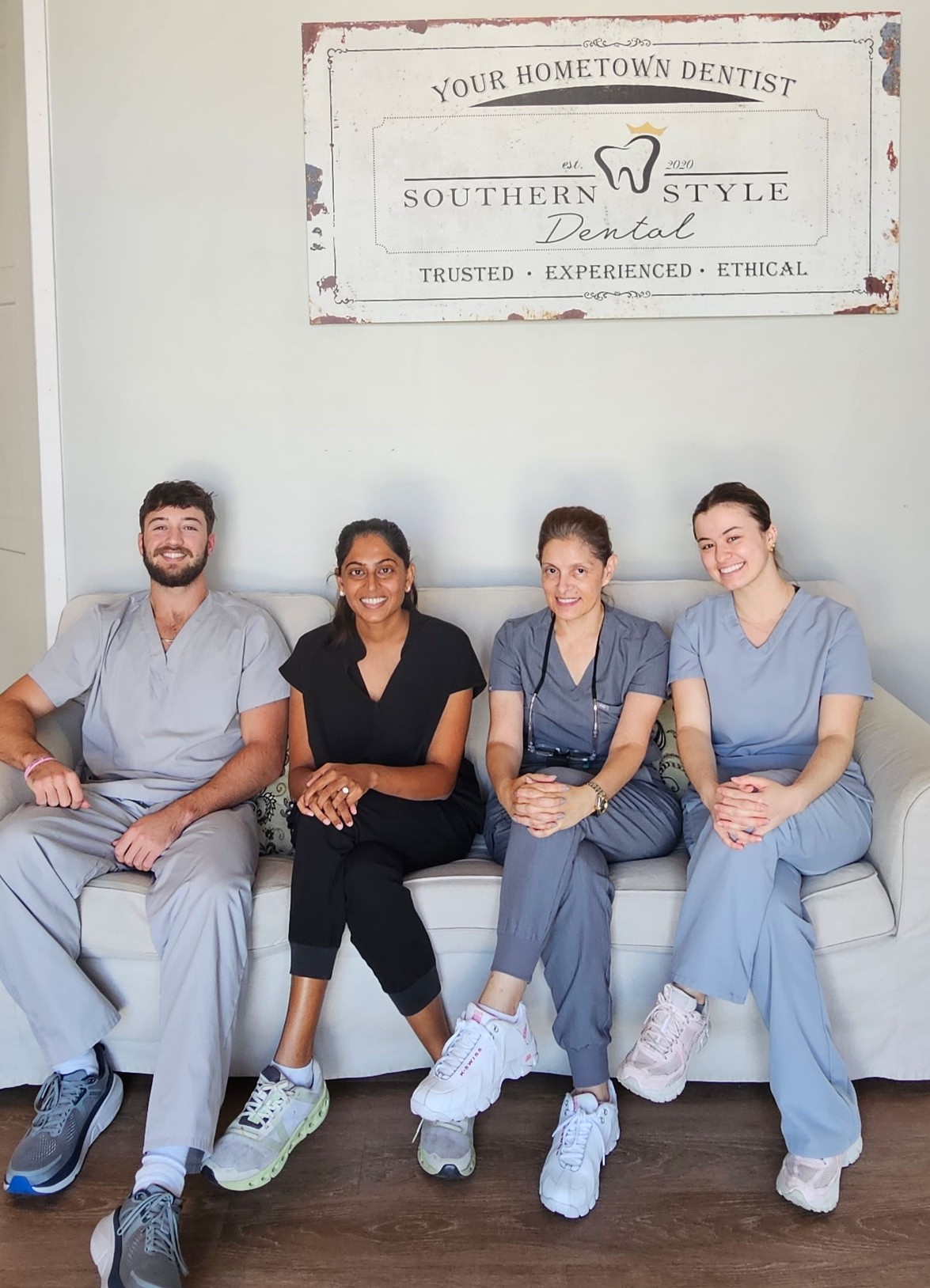 Dental team seated beneath Southern Style Dental sign