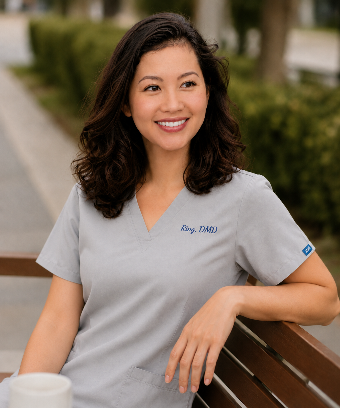 Smiling dentist in gray scrubs outdoors